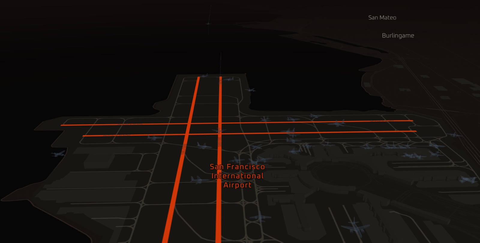 San Francisco International from the south-east, pitched, its runways lit in the accent and aircraft on the field